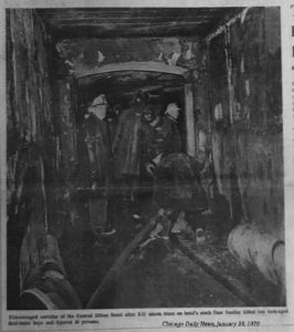 B+W photo of firemen looking at charred corridor