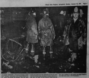 Firemen examine the room where the fire is suspected to have started.